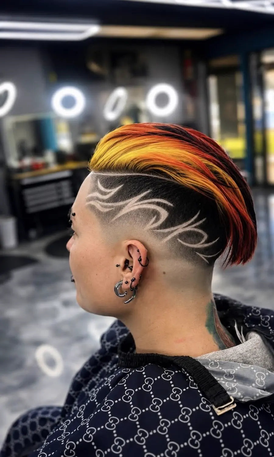A client's freehand shaved hair design and taper, finished with a yellow-to-red colour melt on top
